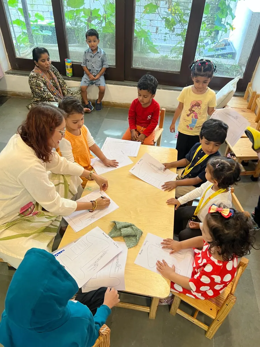 Children doing a tracing activity with their teacher